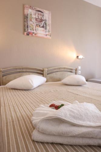 a bedroom with a bed with towels on it at Summer Dream Hotel in Polykhrono