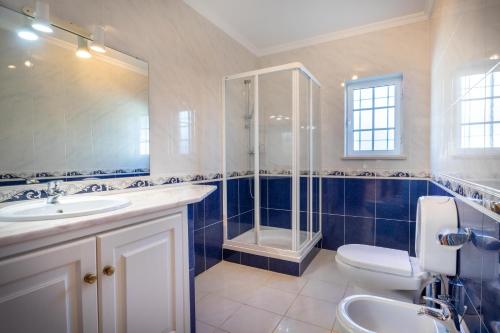 a bathroom with a shower and a toilet and a sink at Villa Goshen in Lagos