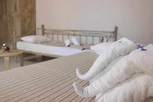 two white towels are stacked on a bed at Summer Dream Hotel in Polykhrono