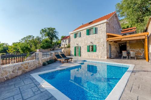 eine Villa mit einem Pool neben einem Gebäude in der Unterkunft Holiday Home Rustic in Kraljići