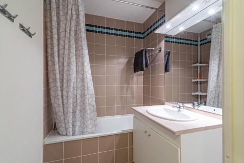 a bathroom with a sink and a tub and a shower at Les Jardins de Ramel - Apt proche des pistes avec Wifi in Luchon
