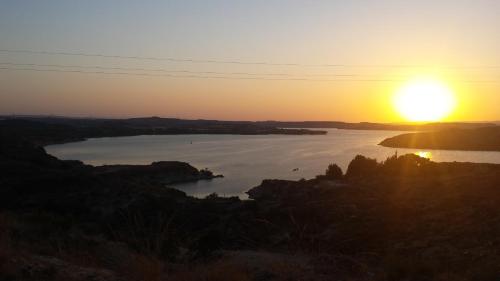a sunset over a large body of water at La Casa de Las Burbujas Azules in Caspe