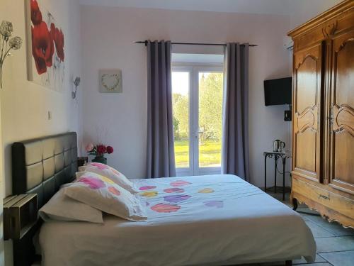 a bedroom with a bed and a sliding glass door at la réveuse in Gordes