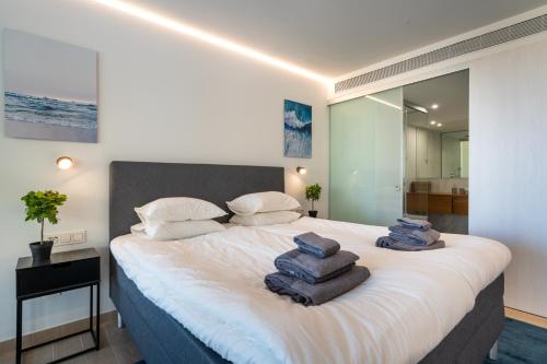 a bedroom with a large bed with towels on it at Holiday Apartment The Wave Carvajal in Fuengirola