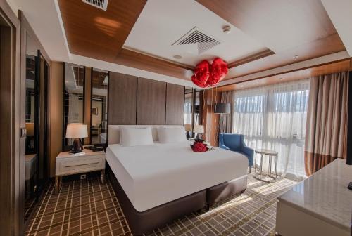 um quarto com uma grande cama branca num quarto em Holiday Inn Kayseri - Duvenonu, an IHG Hotel em Kayseri