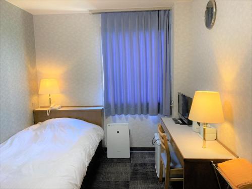 a hotel room with a bed and a desk with a computer at Bayside Hotel Ryugu / Vacation STAY 63706 in Anan