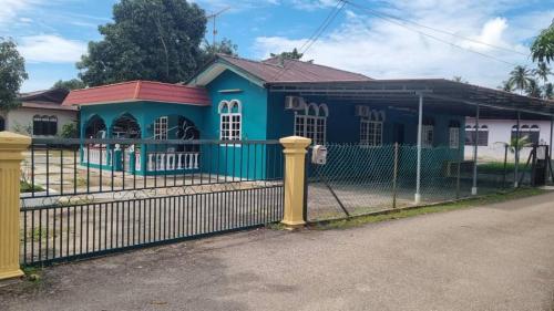 een blauw huis met een hek ervoor bij INAP DESA ABYKAMSHAR in Merlimau