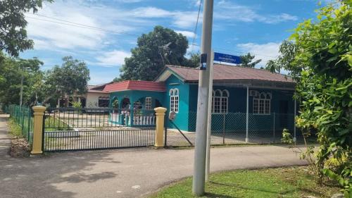 a blue building with a fence in front of it at INAP DESA ABYKAMSHAR in Merlimau