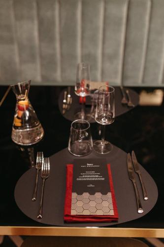 a table with wine glasses and silverware on a table at Hotel Select in Iaşi