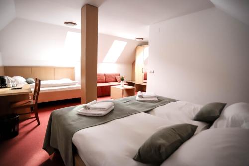 a bedroom with a bed with towels on top of it at Hotel Pino Alpino in Kranjska Gora