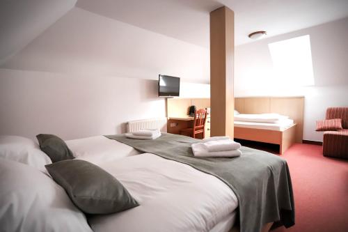 two beds in a hotel room with a bedroom at Hotel Pino Alpino in Kranjska Gora
