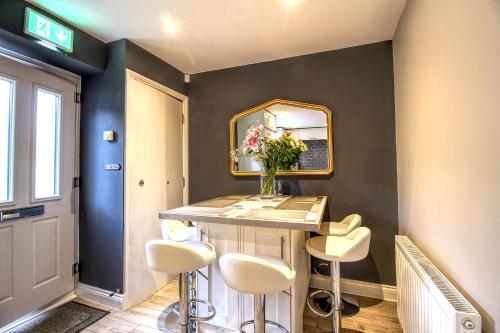 a room with a table with stools and a mirror at 6 Dbl Bed, Central Huddersfield house inc parking in Huddersfield