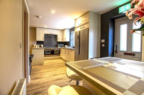 a kitchen with a table and chairs in a room at 6 Dbl Bed, Central Huddersfield house inc parking in Huddersfield