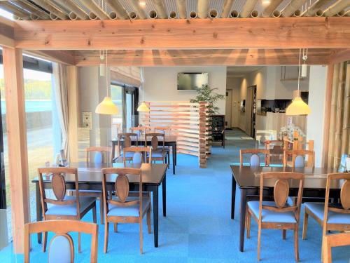 a dining room with wooden tables and chairs at Bayside Hotel Ryugu / Vacation STAY 63714 in Anan