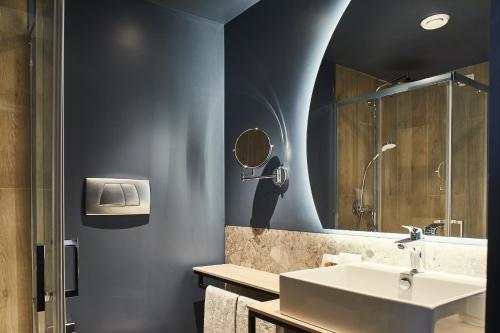 a bathroom with a sink and a mirror at Belstay Milano Linate in Peschiera Borromeo