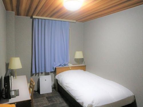 阿南的住宿－Bayside Hotel Ryugu / Vacation STAY 63706，一间卧室配有一张床、一张书桌和一个窗户。