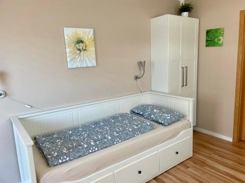 a white bench with two pillows on it in a room at Ferienzimmer/wohnung am Kurstrand, WLAN in Zingst