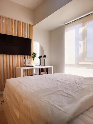 a bedroom with a large bed and a flat screen tv at Steff's CONDO 1016 at CENTRIO Tower in Cagayan de Oro