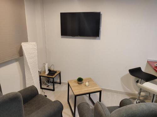 sala de estar con sofá y TV en la pared en Apartamento Madrid Norte, en Madrid