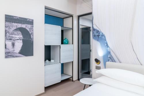 a bedroom with white furniture and a mirror at Hotel Veronesi La Torre in Dossobuono