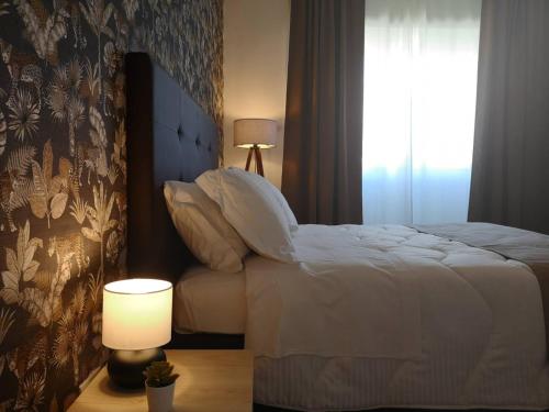 ローマにあるHH Vatica Suite IIのベッドルーム1室(ベッド1台、ランプ、窓付)