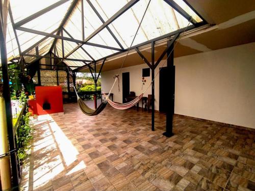 a large room with a hammock in a building at Finca Los Tres Reyes in Guamal