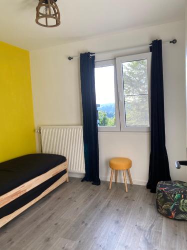 a bedroom with a bed and a window and a stool at Sol Borsay - Studio de vacances à la campagne - Idéal pour 2 in Comblain-au-Pont