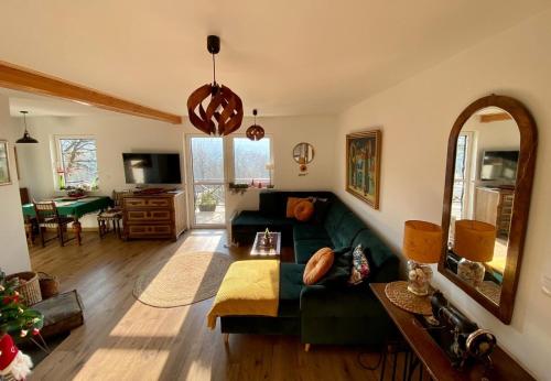 a living room with a green couch and a mirror at Klimatyczny Dom z widokiem na Babią Górę in Maków Podhalański