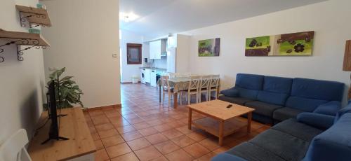 sala de estar con sofá azul y mesa en Casa Rural Miralmonte, en San Leonardo de Yagüe