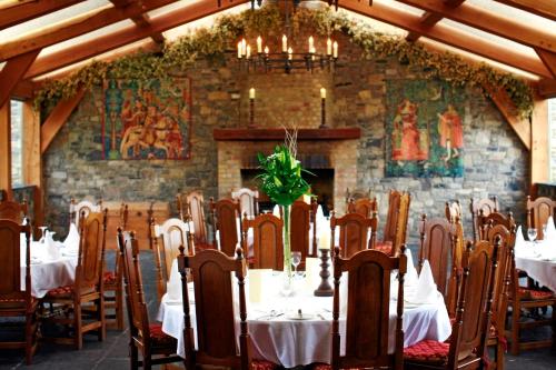 a dining room with tables and chairs and a stone wall at Barberstown Castle in Straffan