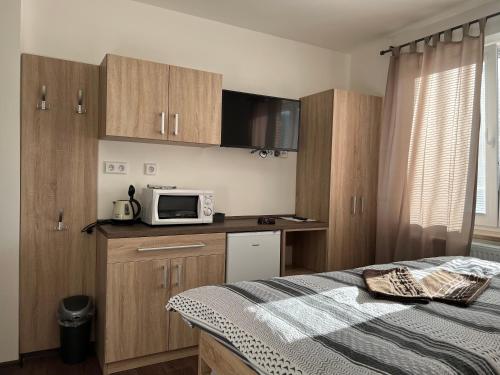 a bedroom with a bed and a microwave on a counter at Penzion Na Rozcestí in Bulhary