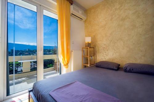 a bedroom with a bed and a large window at Sea view Penthhouse in Souda