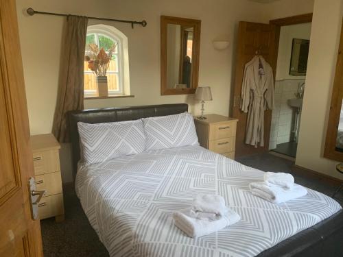 sypialnia z łóżkiem z ręcznikami w obiekcie The Cottage At The Retreat w mieście Leek