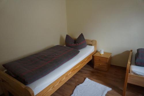 een slaapkamer met een bed met 2 kussens erop bij Ferienwohnung Helbing in Marlishausen