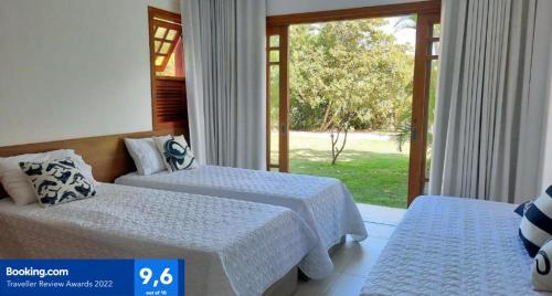 um quarto de hotel com duas camas e uma janela em PRAIA DO FORTE - PISCINAS NATURAIS em Praia do Forte