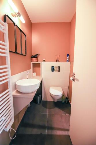 une salle de bain avec un lavabo blanc et des toilettes dans l'établissement Les Halles Positives, Draps compris et Climatisation, à Sarlat-la-Canéda