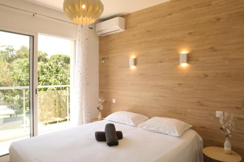 een slaapkamer met een wit bed met een houten wand bij Villa Marine en bord de mer... in Lumio