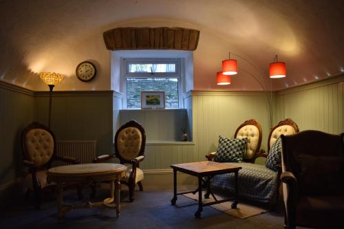 a living room with chairs and a table and a window at Crug Glas Country House in St. Davids