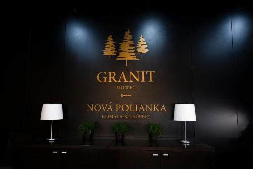 a sign for a hotel with pine trees on a wall at Hotel Granit Nová Polianka*** - klimatické kúpele in Vysoké Tatry
