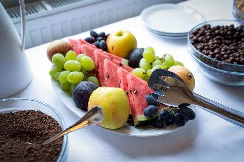 a plate of fruit on a table with a bowl of nuts at Hotel Granit Nová Polianka*** - klimatické kúpele in Vysoké Tatry