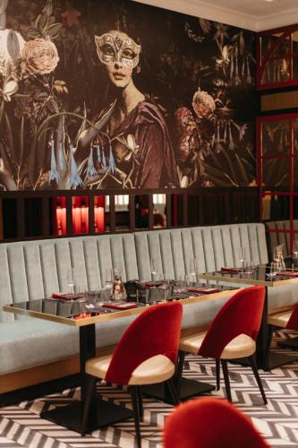 a dining room with a table and red chairs at Hotel Select in Iaşi