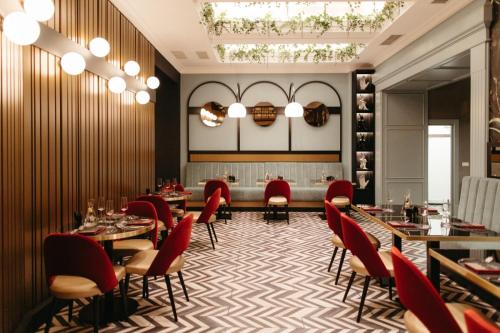 a restaurant with red chairs and tables in a room at Hotel Select in Iaşi
