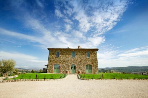 a large stone house on a hill with a blue sky at Colle Galli in Acquapendente