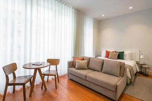a bedroom with a bed and a couch and a table at Porto River Infante in Porto