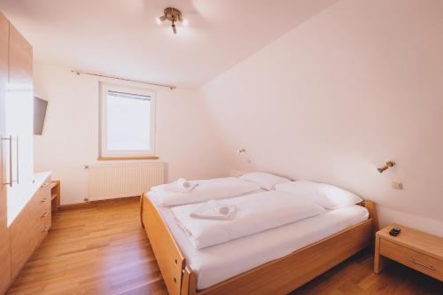 a bedroom with a bed with white sheets and a window at Panorama Chalet Schmittendrin by we rent, SUMMERCARD INCLUDED in Zell am See