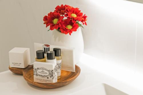 a table with a bouquet of flowers and some products at Porto River Infante in Porto