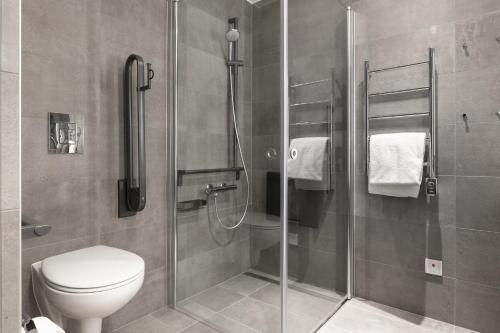 a bathroom with a toilet and a glass shower at Lapland Hotels Arena in Tampere