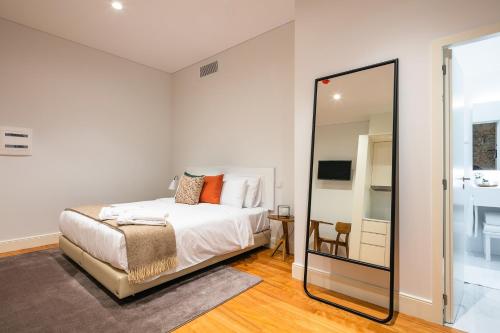 a bedroom with a bed and a mirror at Porto River Infante in Porto