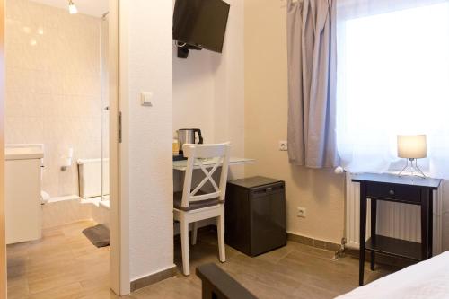 Zimmer mit einem Schreibtisch und einem Stuhl in einem Zimmer in der Unterkunft Hotel Frankenthaler Hof in Frankenthal