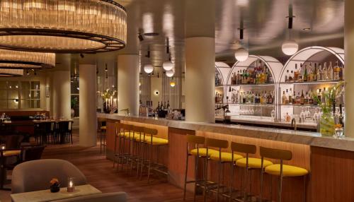 a bar in a restaurant with yellow bar stools at Hôtel Reisen in The Unbound Collection by Hyatt in Stockholm
